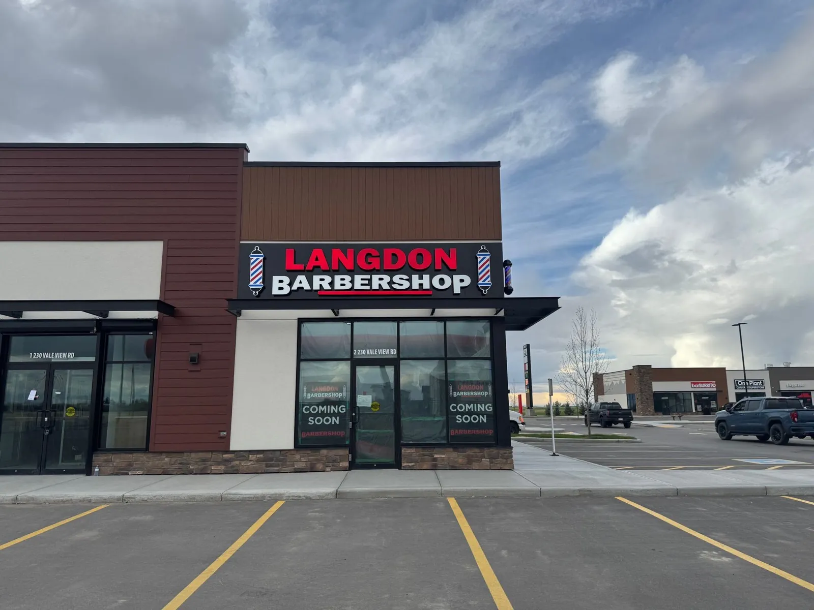 Langdon Barbershop corner storefront with red channel letters and coming soon window graphics