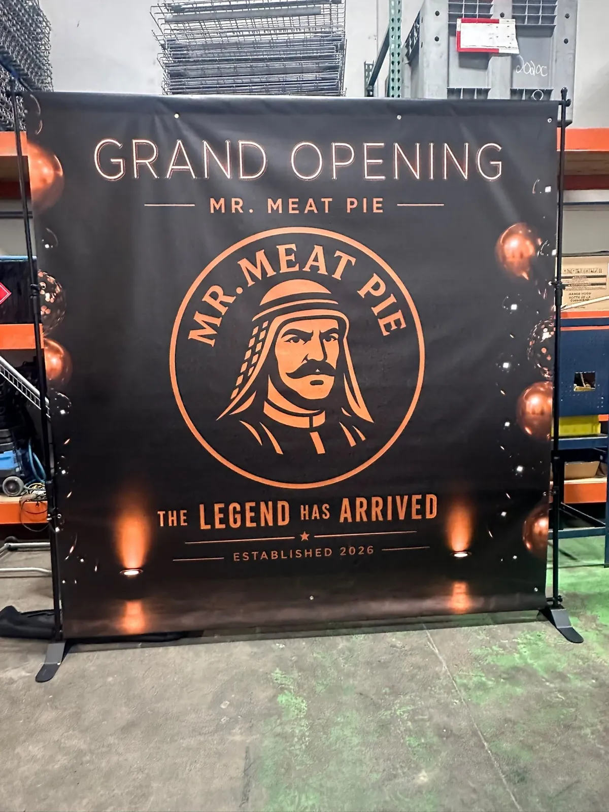 Mr. Meat Pie grand opening printed backdrop banner on a stand